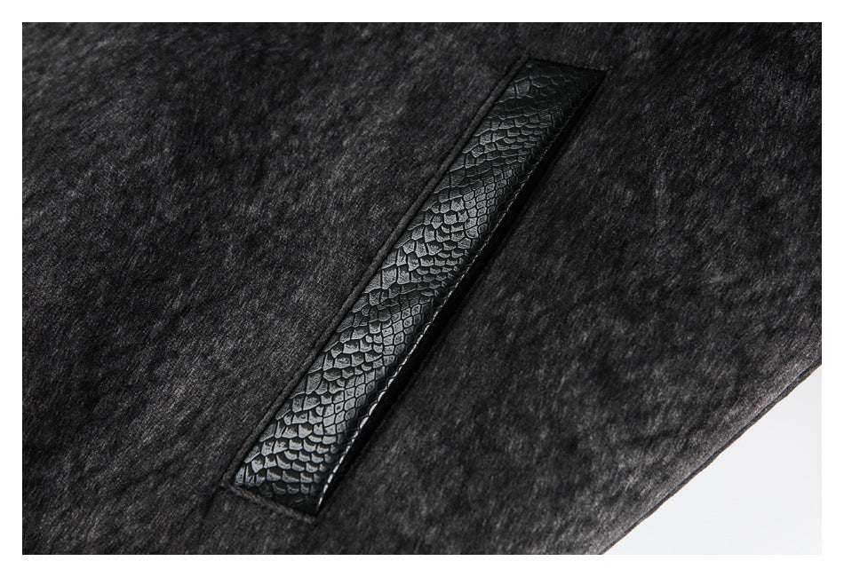 Close-up of a narrow black reptile-textured trim panel set into the charcoal jacket.