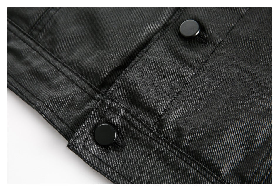 Close-up of the black jacket’s lower edge, stitching, and two black snaps.