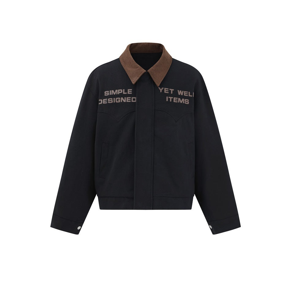 Black cropped collared jacket with brown corduroy-style collar, chest slogan text, western yoke seams and snap cuffs