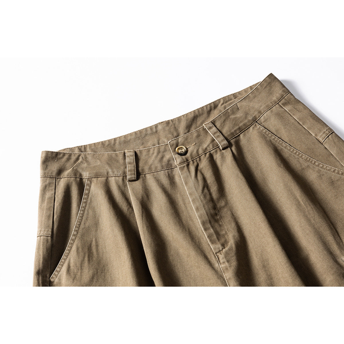 Close-up of khaki-brown cargo shorts showing the waistband, button, belt loops, pleats and front pocket.