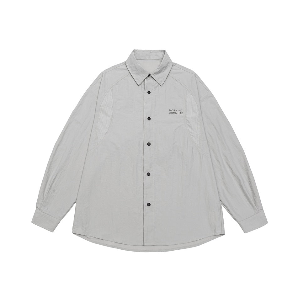 Light beige-gray long-sleeve button-front shirt with black snaps, raglan sleeves and mesh-like side panels, flat lay