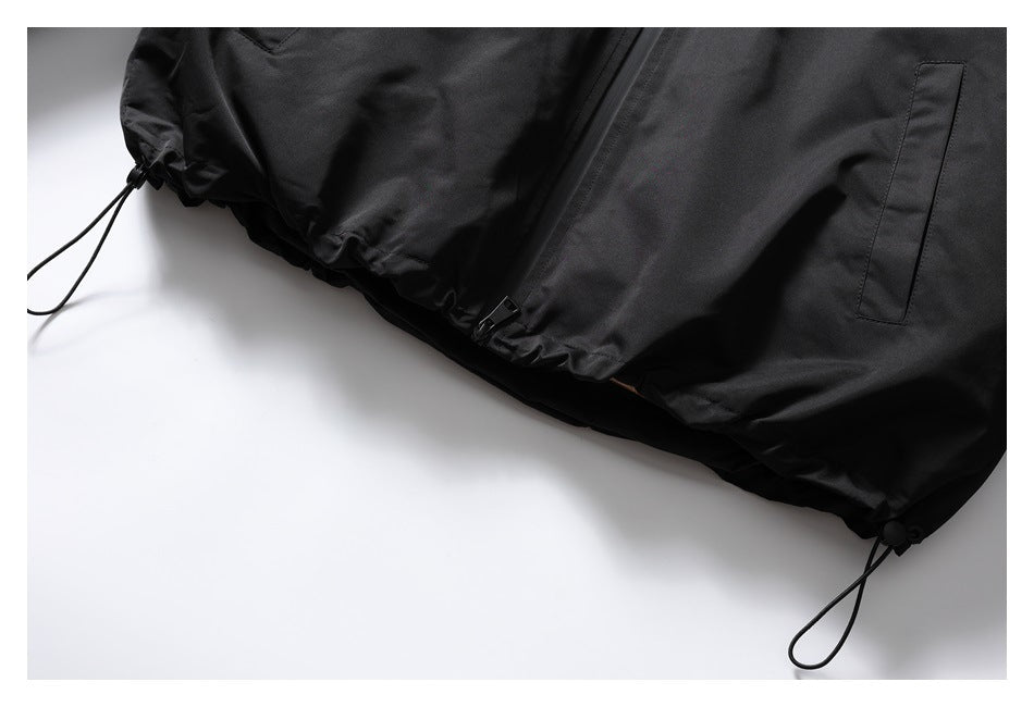 Close-up of the black jacket hem with a zipper, side pocket, and adjustable drawcords.