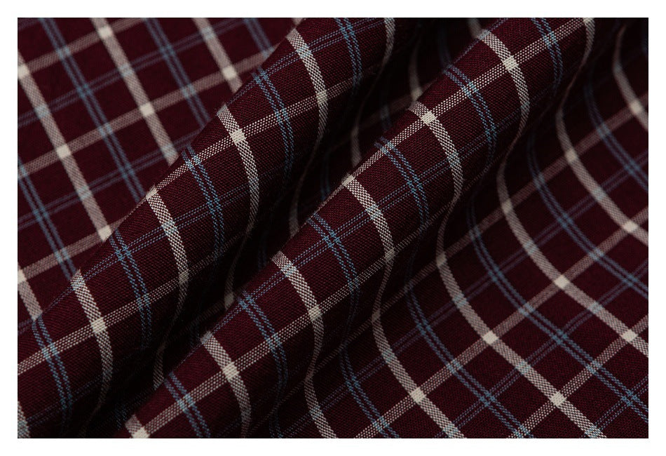 Close-up of burgundy plaid fabric with cream and thin blue intersecting stripes.