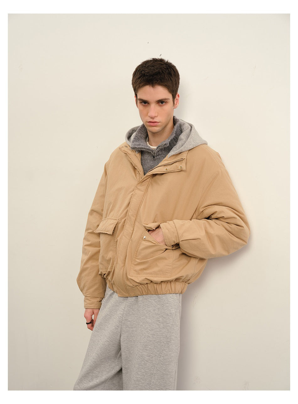Model wearing a tan hooded jacket with a front closure, flap pockets and an elasticized hem.