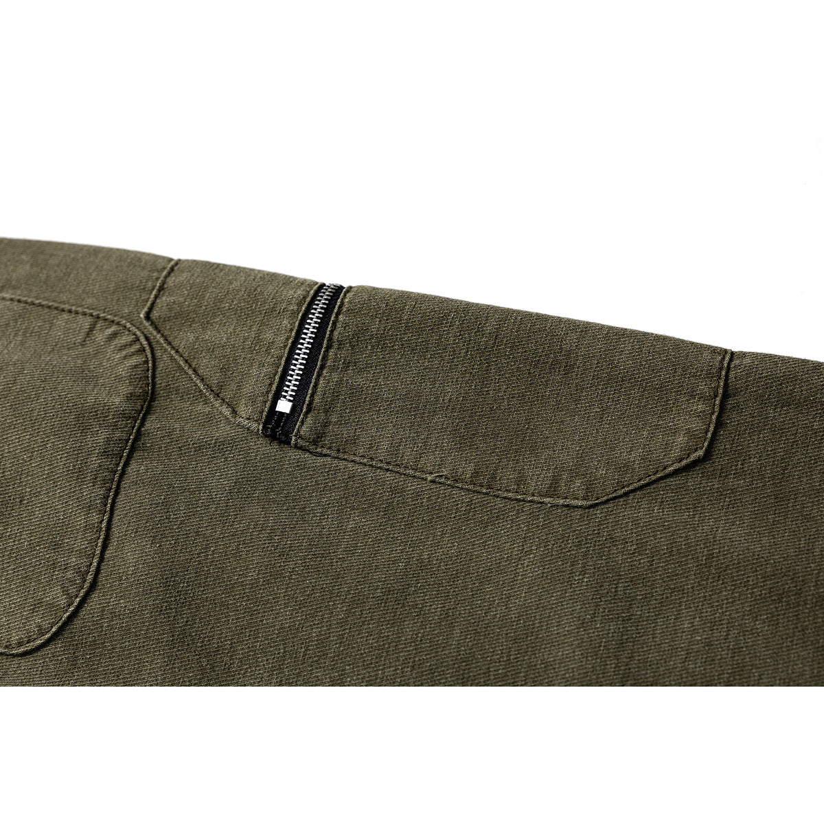 Close-up of an olive trouser pocket with a vertical metal zipper and stitched seams.
