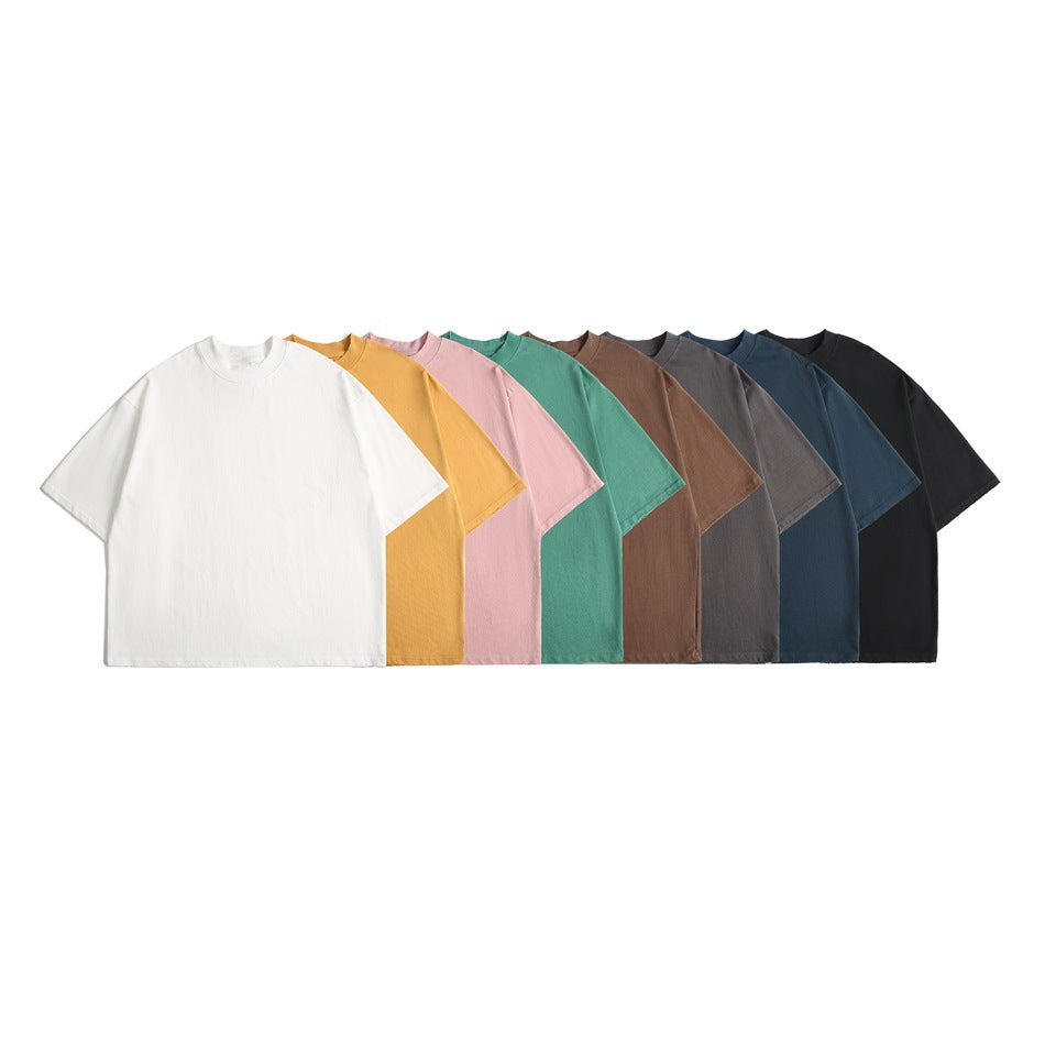 A row of plain short-sleeve T-shirts in white, mustard, pink, teal, brown, gray, blue, and black.