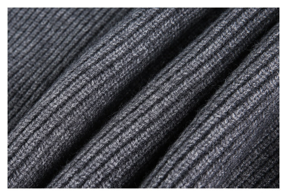 Macro close-up showing the charcoal garment's textured ribbed knit stitches.