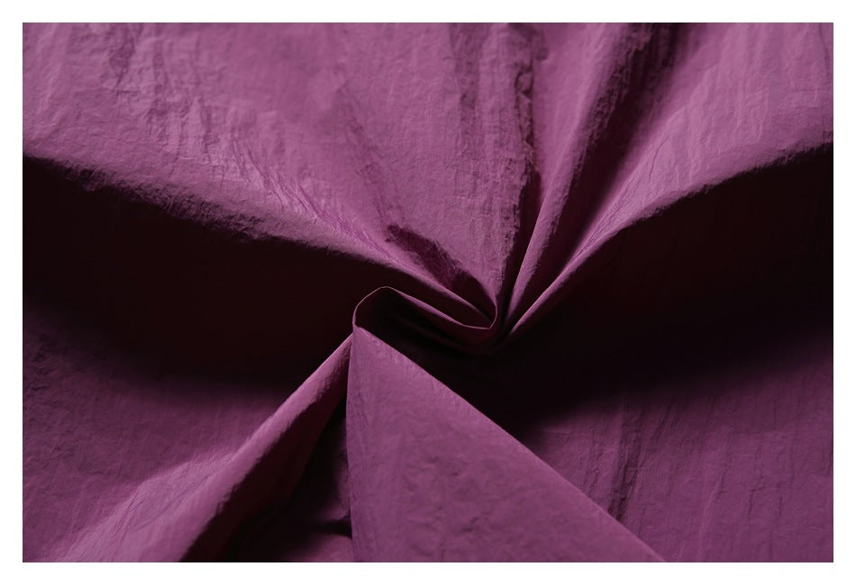 Close-up of crinkled purple fabric arranged in deep folds.