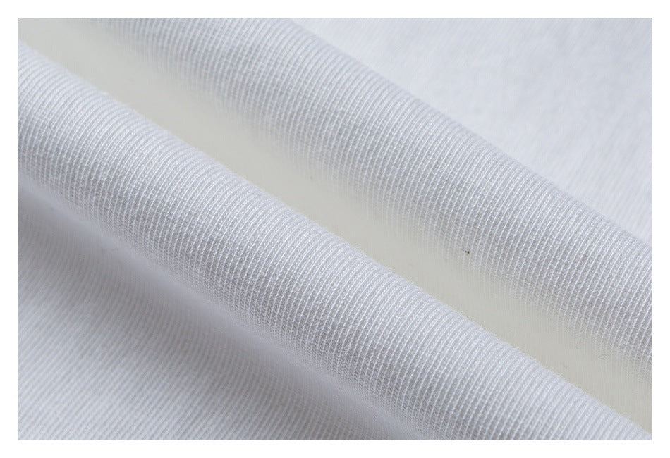 Macro view of white T-shirt fabric folded to show its knit texture.