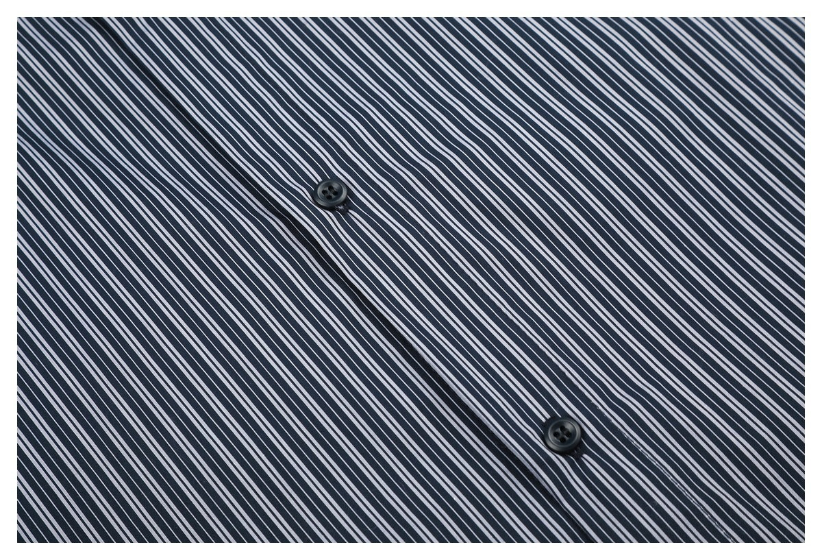 Close-up of the dark button placket on a navy shirt with narrow white stripes.