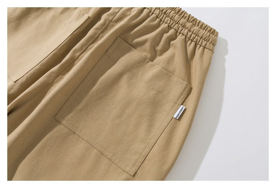 Close-up of tan pants with an elastic waistband and a large rectangular patch pocket.