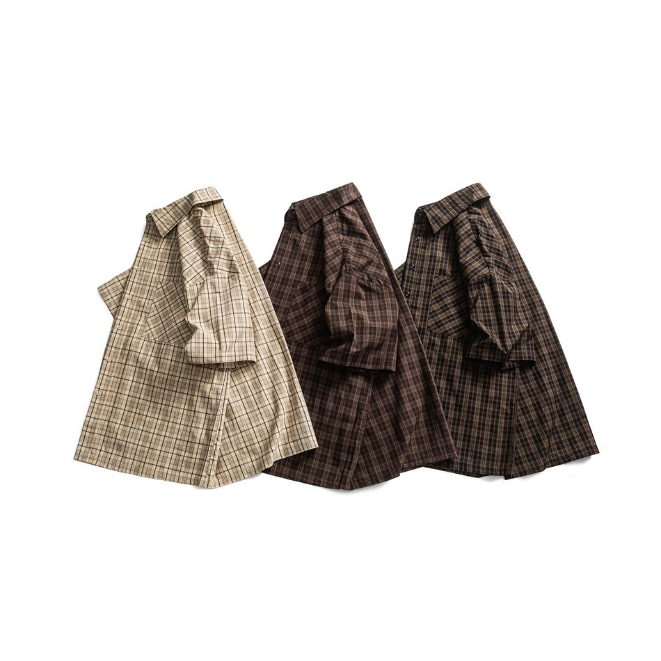 Three plaid short-sleeve shirts in apricot, coffee brown and black laid side by side at an angle