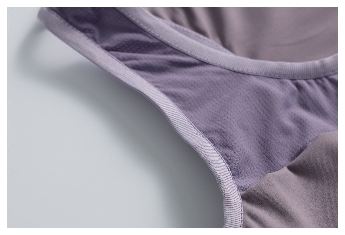 Close-up of lavender mesh fabric and ribbed binding along the armhole of an athletic top.