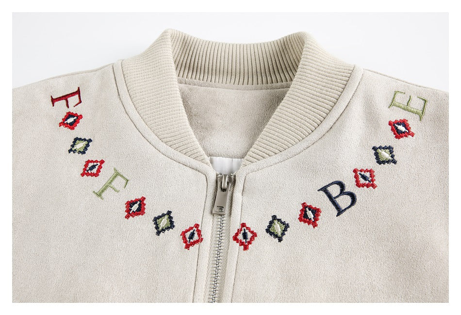 Close-up of the cream jacket's ribbed collar, zipper, and colorful embroidered letters and geometric motifs.
