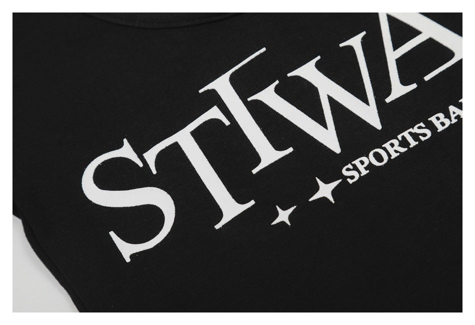 Tight close-up of the white serif “STWAUP” print and stars on black fabric.