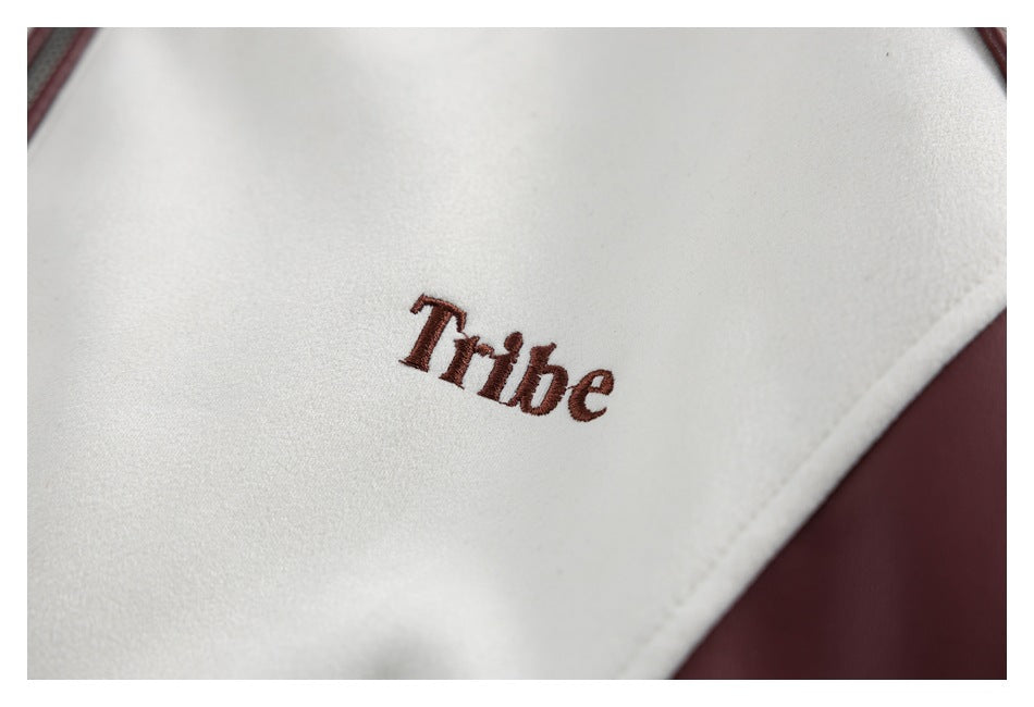 Close-up of burgundy embroidered lettering on an ivory jacket panel with burgundy trim.