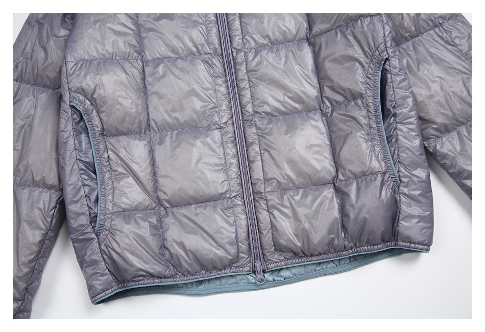 Close-up of the gray quilted jacket front, showing two zippered pockets, center zipper, and blue-gray lining trim.