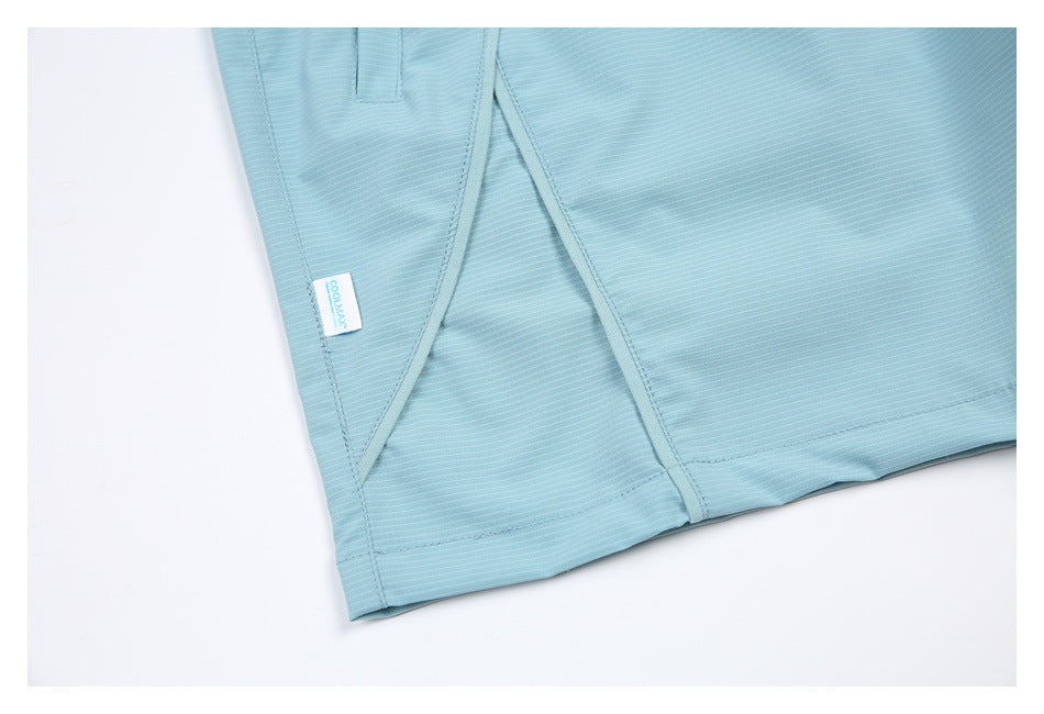 Close-up of light blue finely striped garment hem and stitched panels, with a small COOLMAX tag.