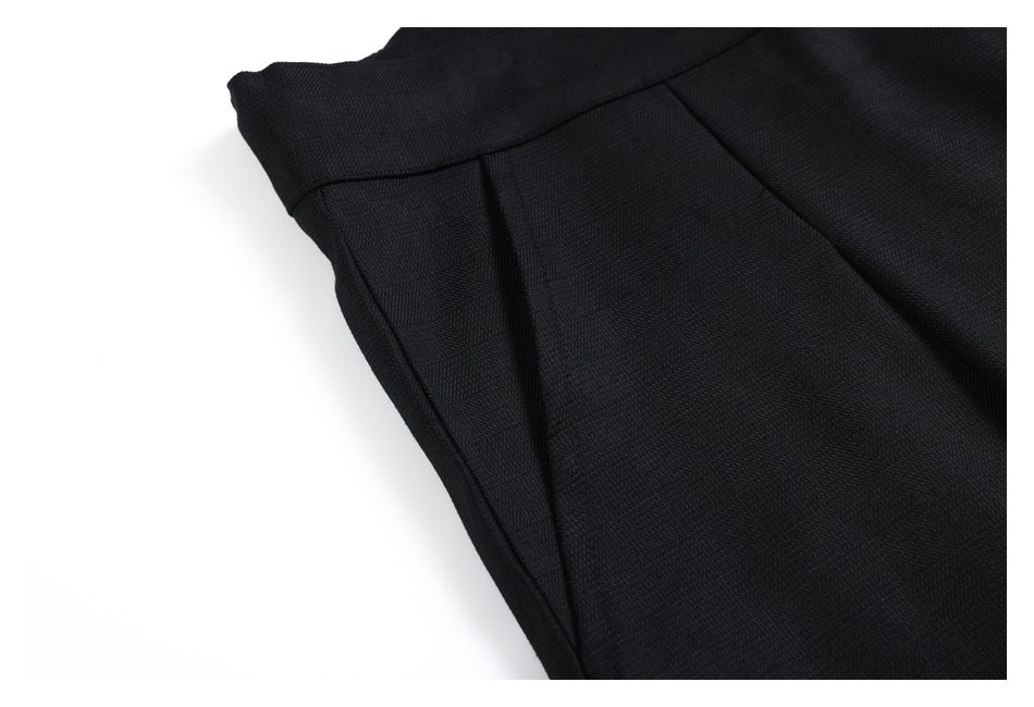 Close-up of black trousers showing the side seam and pocket area.