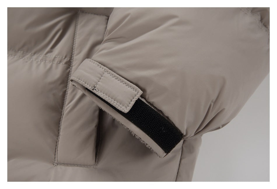 Close-up of the taupe jacket sleeve's adjustable hook-and-loop cuff strap.