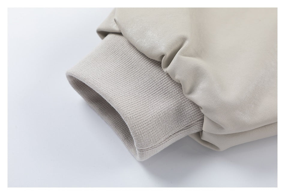 Close-up of a light beige jacket sleeve with a wide rib-knit cuff.