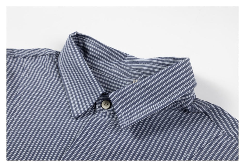 Close-up of a blue-gray shirt collar with narrow white vertical stripes and a cream button.