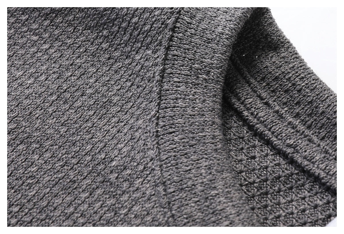 Close-up of the gray top's textured fabric and stitched edge near the armhole.