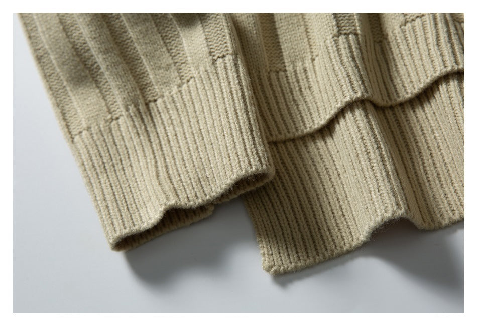 Close-up of the beige sweater's ribbed sleeve cuff beside its ribbed hem.