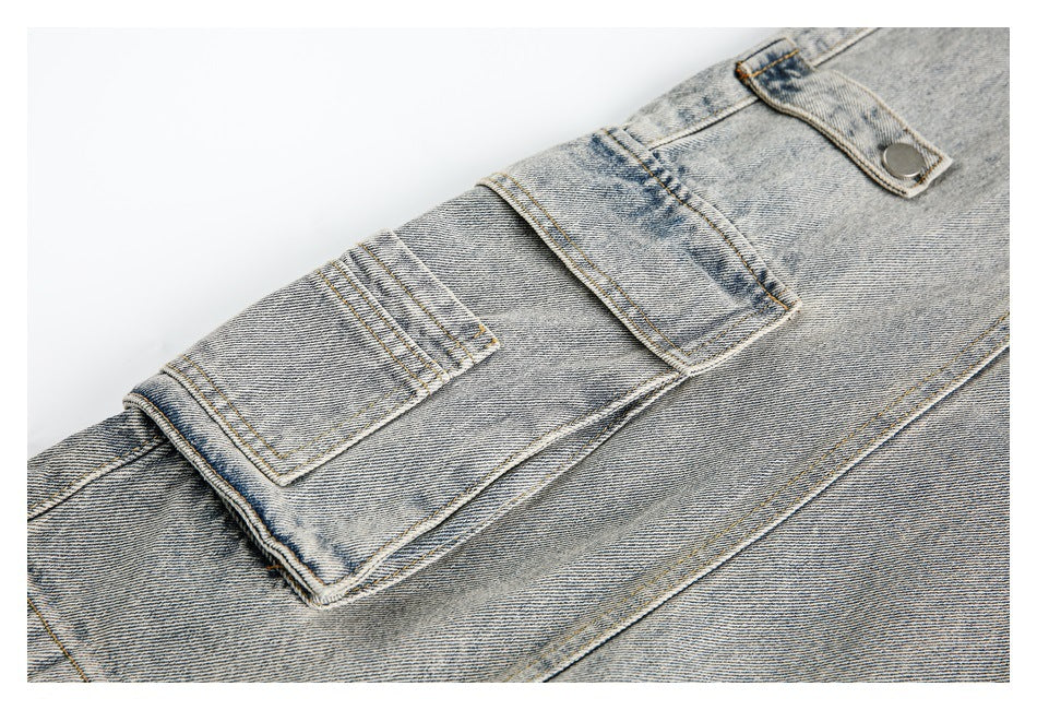 Close-up of a large flap pocket with a button on light-wash denim.