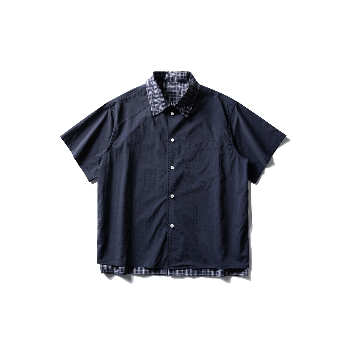 Navy short-sleeve button-up shirt with plaid collar, chest pocket and plaid layer at the hem, front flat lay