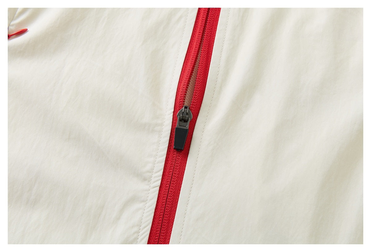 Close-up of the cream garment's red front zipper and black zipper pull.