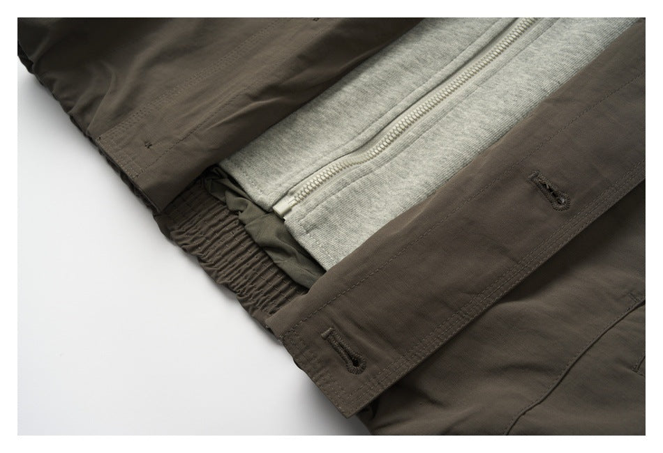 Close-up of the garment opened to show a gray knit inner zip layer and dark buttoned outer placket.