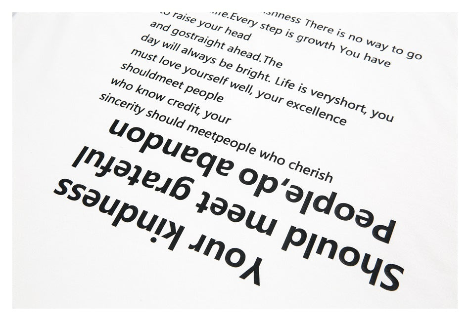 Angled close-up of a white T-shirt with a large black English text print.