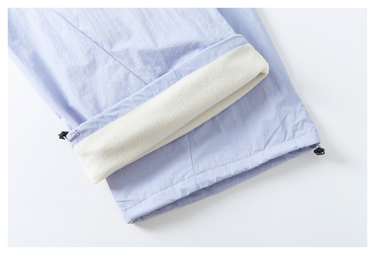 Close-up of a pale lavender pant leg with the cuff turned back to show a cream fleece-like lining.