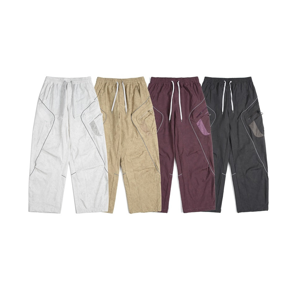 Four pairs of loose cargo trousers shown together in white, tan, plum, and charcoal.