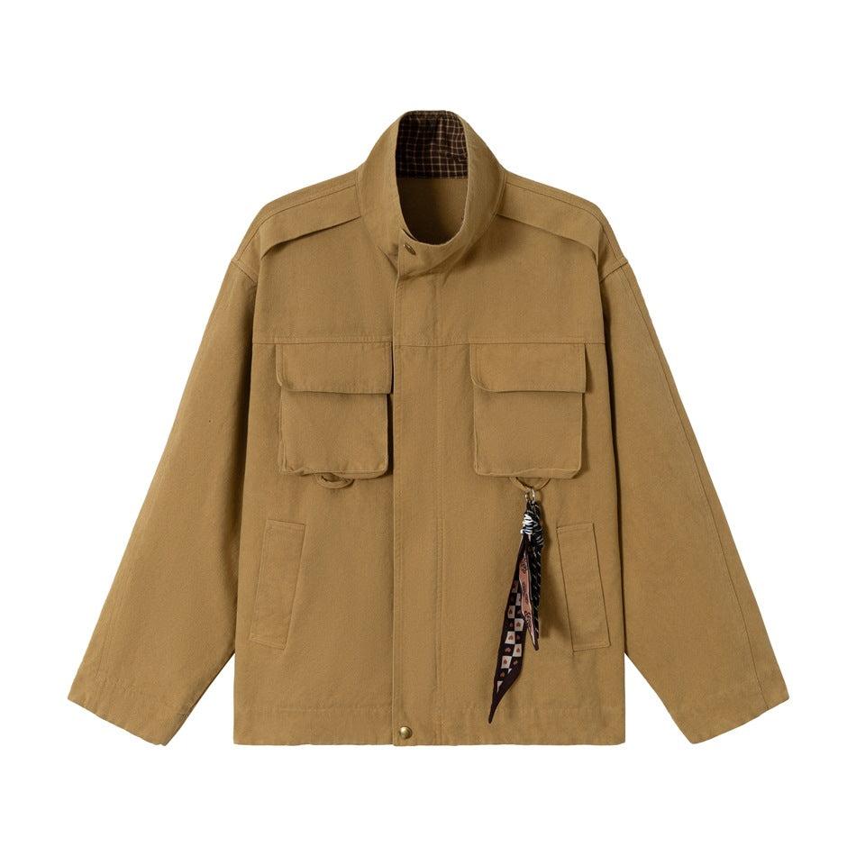 Brown stand-collar jacket flat lay with two flap chest pockets, front zip and a patterned scarf charm