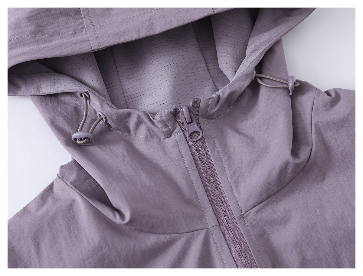 Close-up of a muted lavender jacket hood, showing perforated lining, drawcord toggles, and the front zipper.