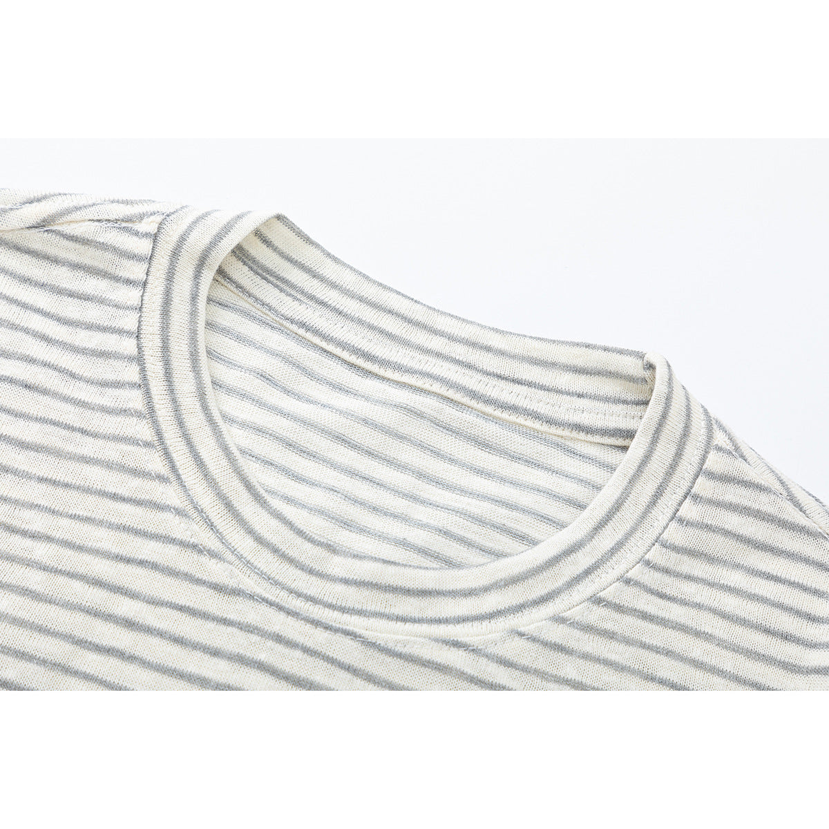Close-up of a cream-and-gray striped shirt's ribbed crew neckline and shoulder area.