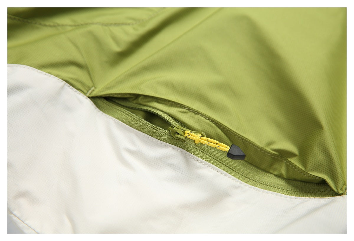 Close-up of a zippered pocket opening across lime-green and white garment panels.