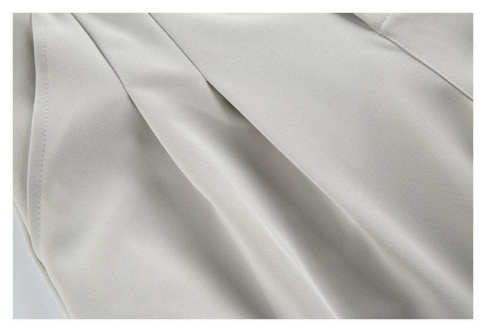Close-up of the light beige trouser fabric and a stitched seam.