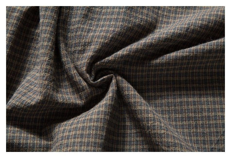 Close-up of brown, blue, and tan checked fabric gathered into soft folds.
