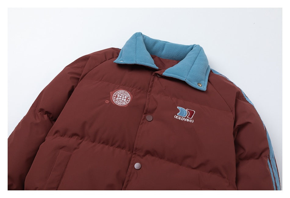 Partial front view of a burgundy padded jacket with a blue fleece collar, snap closures, sleeve stripes, and embroidered
