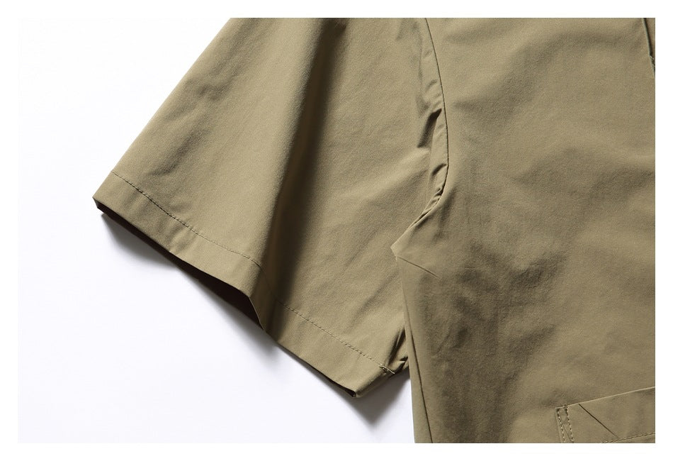 Close-up of the olive-khaki shirt's short sleeve, side seam and edge of the chest pocket.