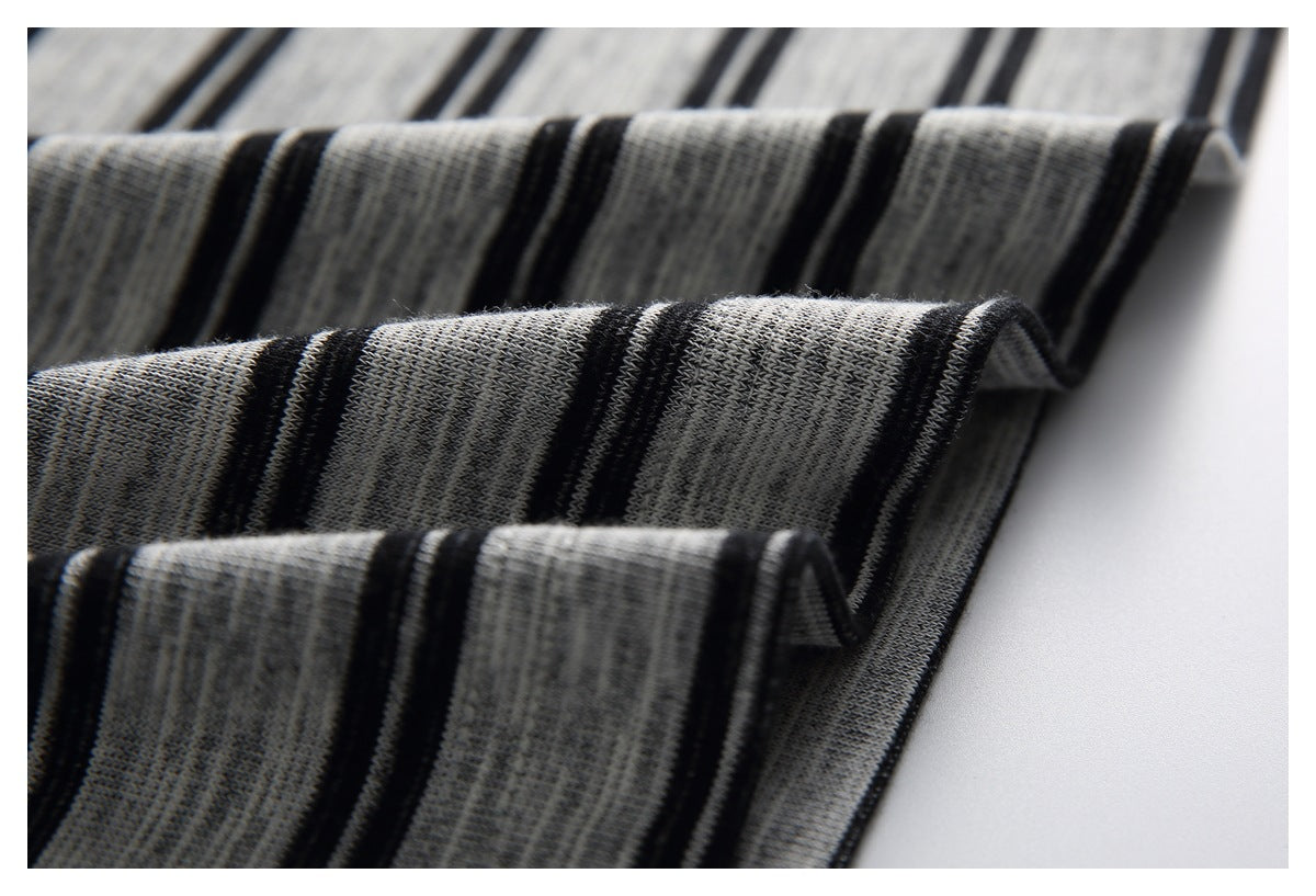 Close-up of gray knit fabric with black stripes folded in layered waves.