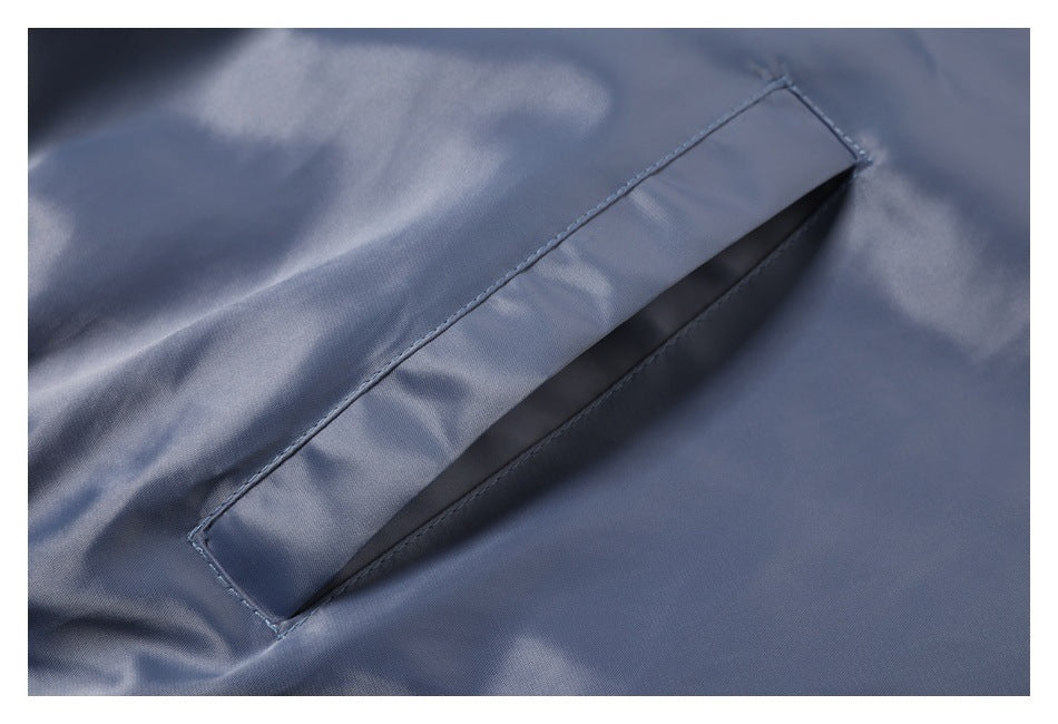 Close-up of a slanted welt pocket on slate-blue garment fabric.