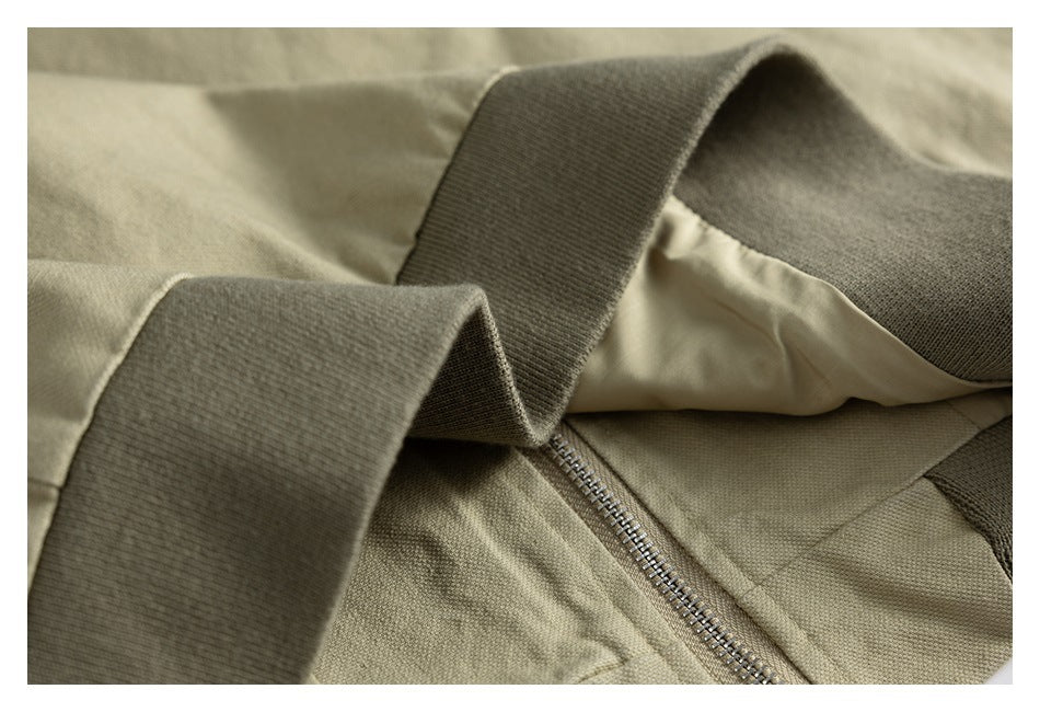 Close-up showing the khaki garment's ribbed collar trim, inner lining, and metal zipper.