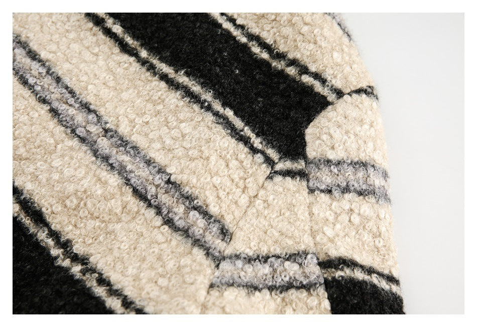 Close-up of a curved seam on the cream, gray, and black striped fuzzy jacket.