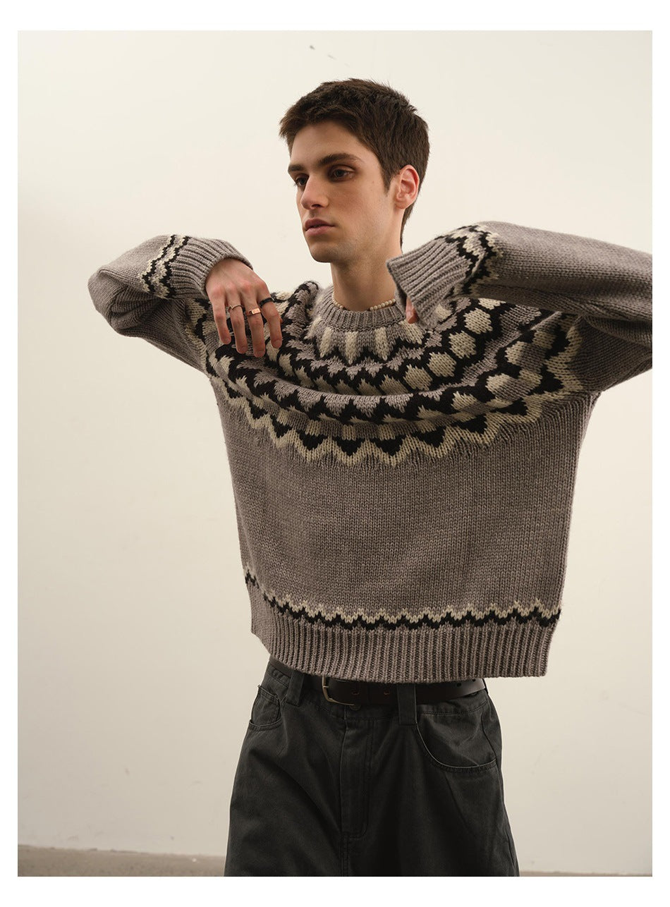 Model lifts his arms to show the fit and Fair Isle pattern of a taupe crew-neck sweater.