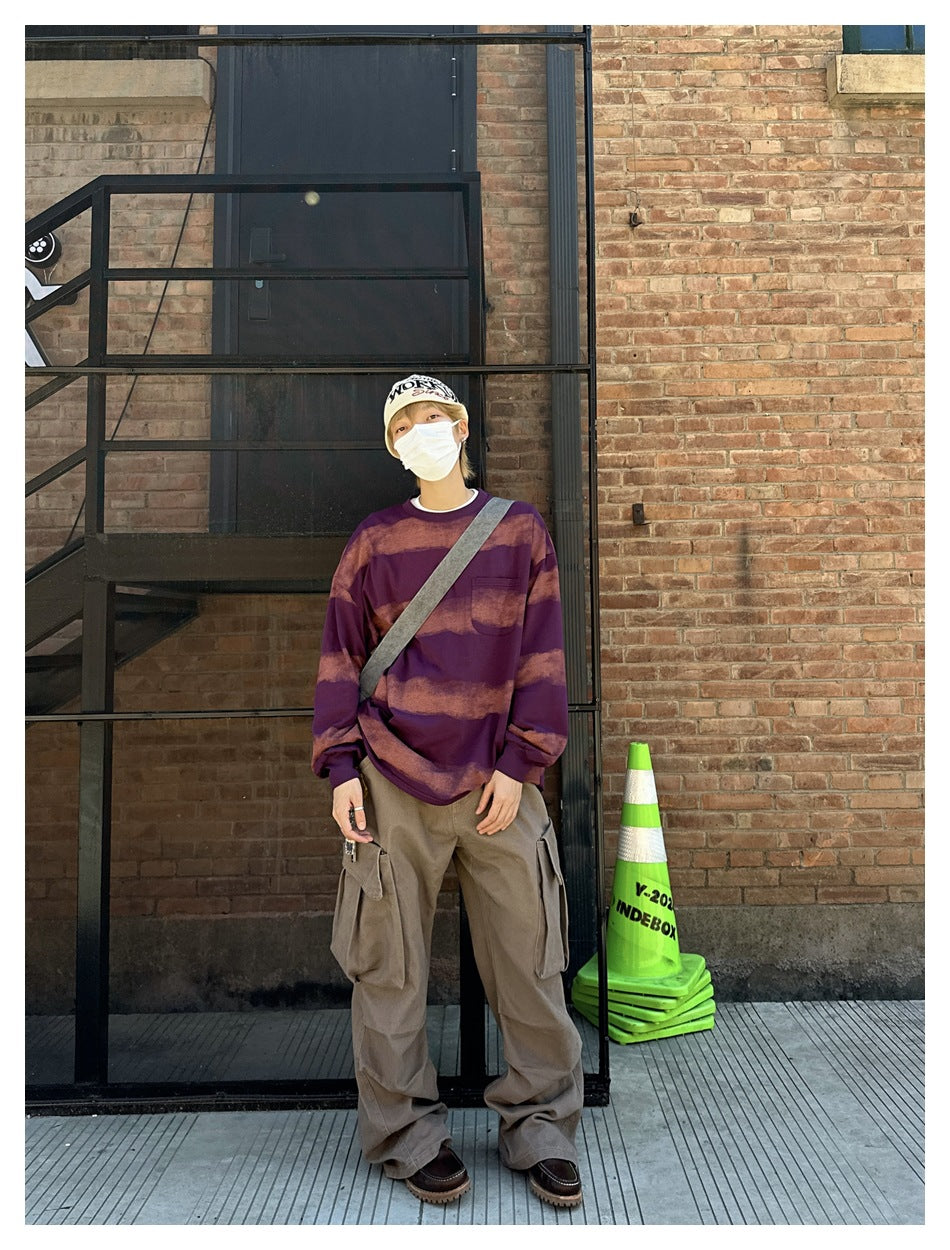 Person in khaki wide-leg cargo pants with a purple striped top, standing against a brick wall