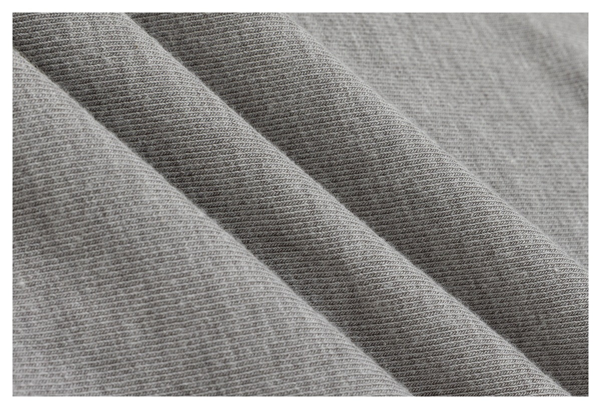 Close-up of gray fabric with a fine diagonal knit texture, arranged in soft folds.